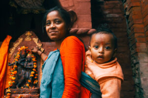 a woman carrying a child in a sling