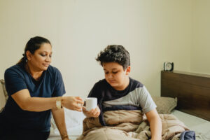 a woman sitting next to a child on a bed