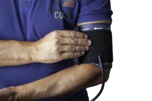 a man with a cast on his arm holding a blood pressure meter