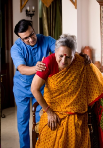 A male nurse is helping a woman sit down.