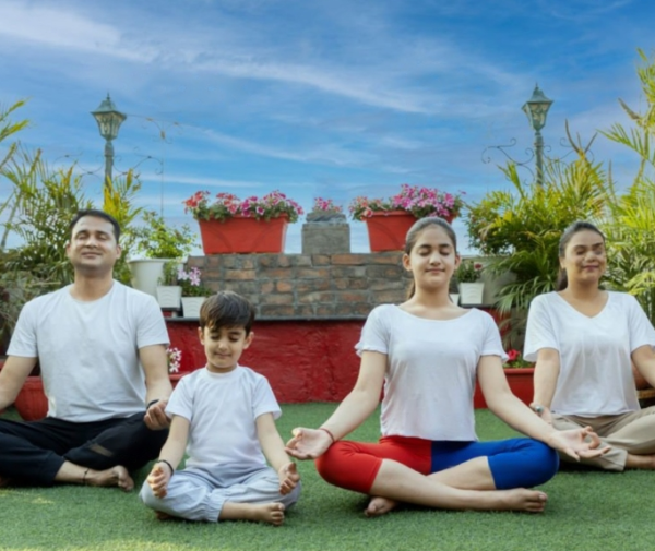 a group of people sitting on top of a lush green field