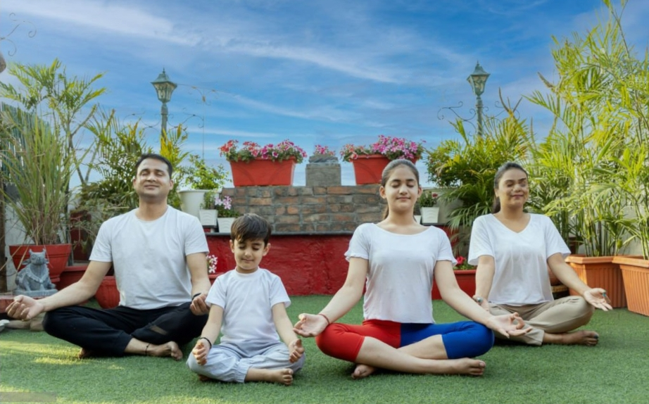 a group of people sitting on top of a lush green field